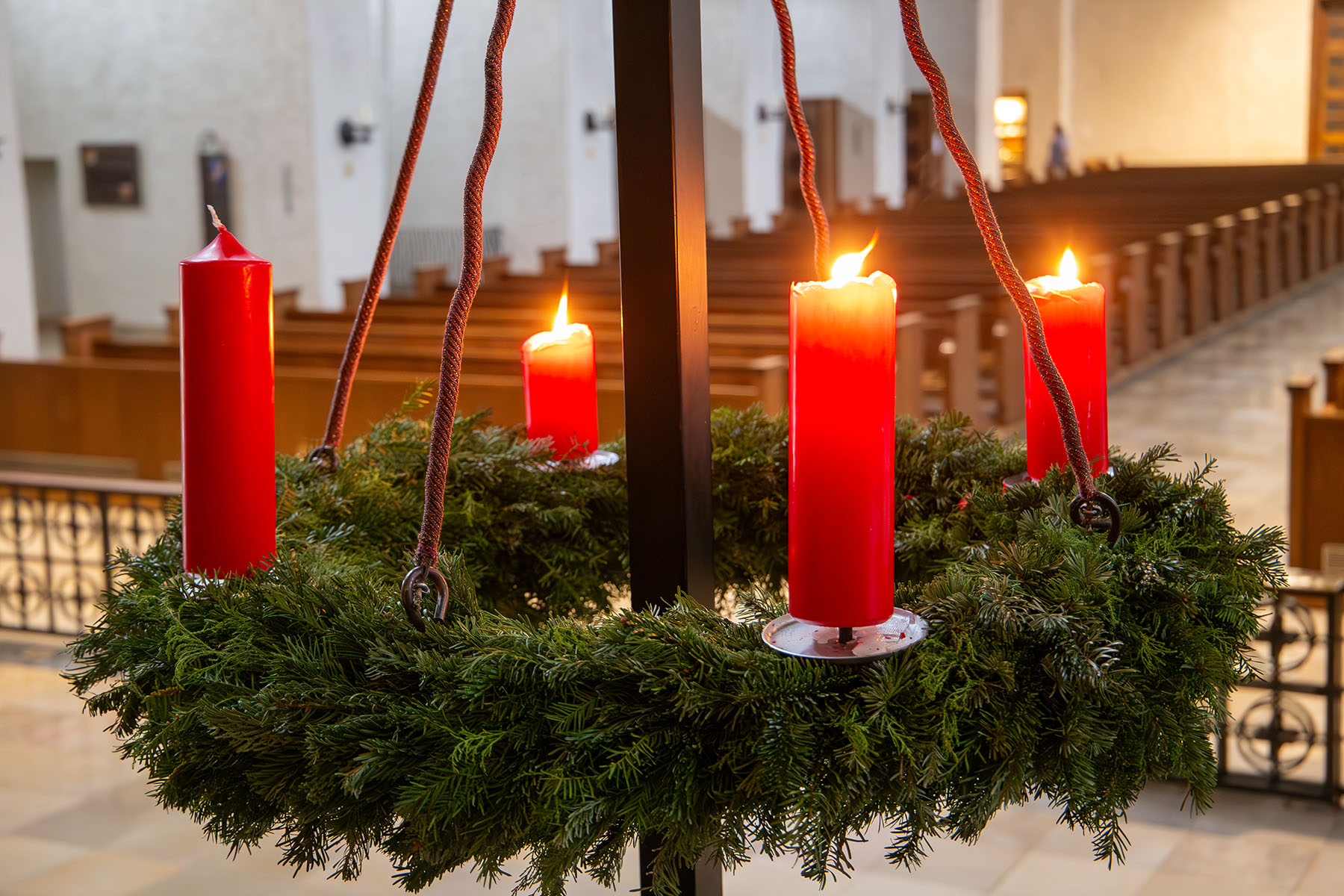 Adventskranz, bei dem drei Kerzen angezündet sind.