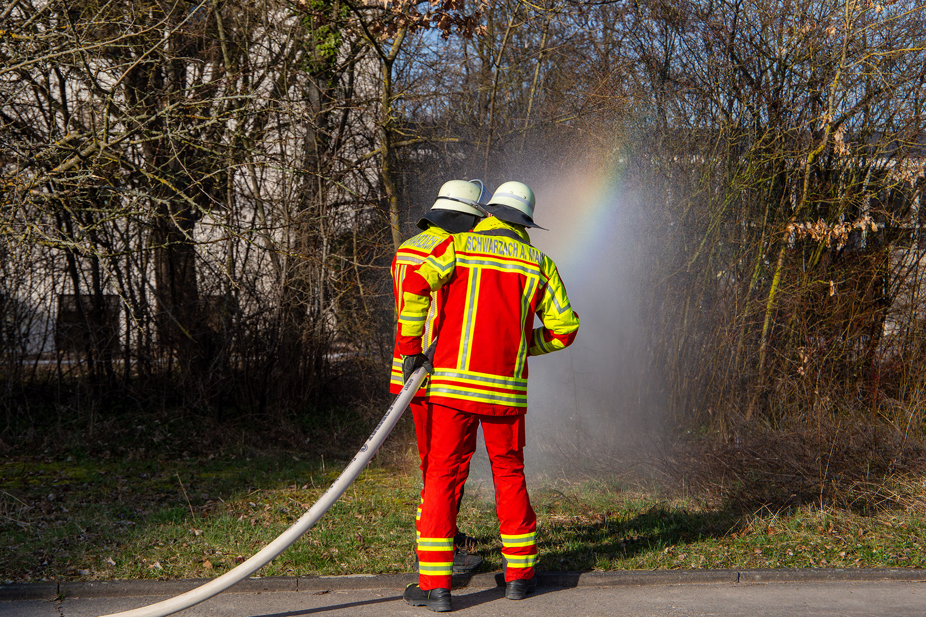 Zwei Männer mit Feuerwehrschlauch