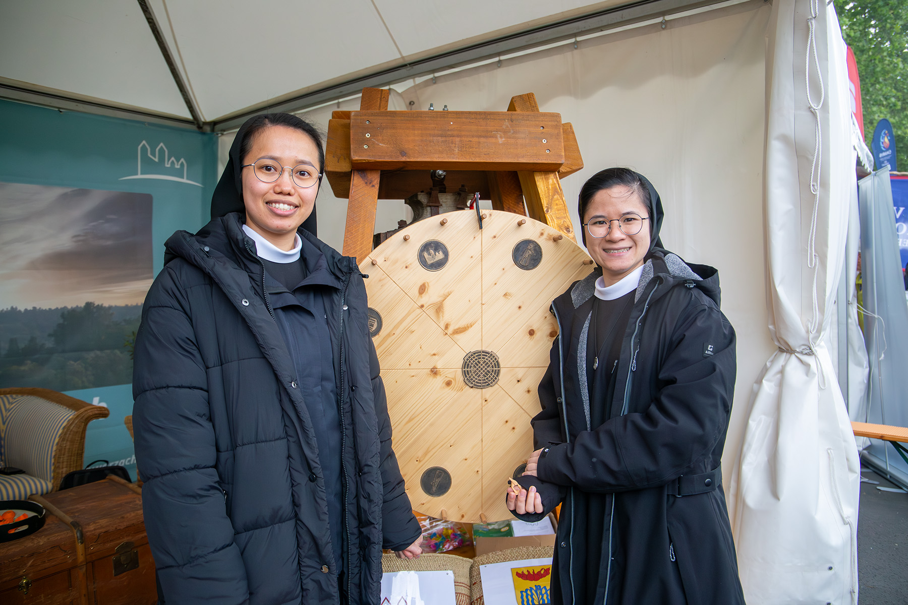 Zwei Schwestern in Tracht am Glücksrad aus Holz