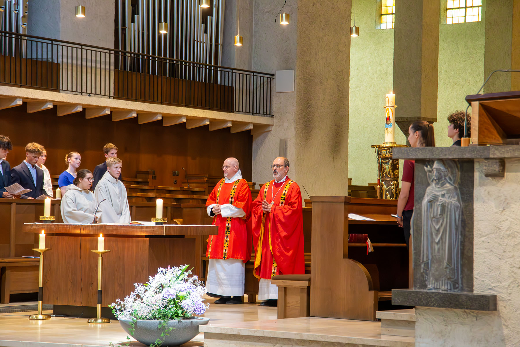 Blick in die Kirche, vorne stehen zwei Männer in roten Gewändern