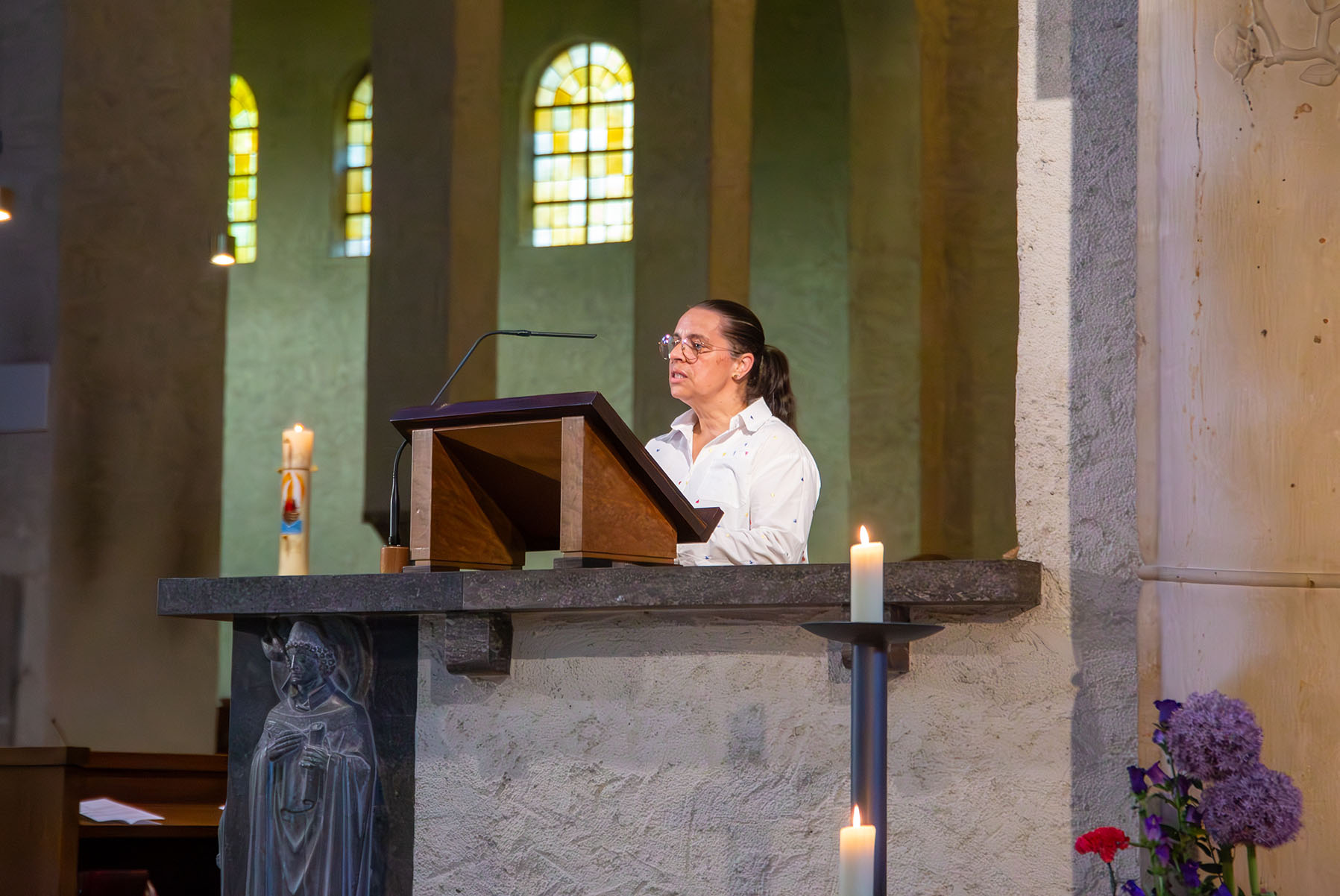 Frau mit Brille auf Kanzel in Kirche