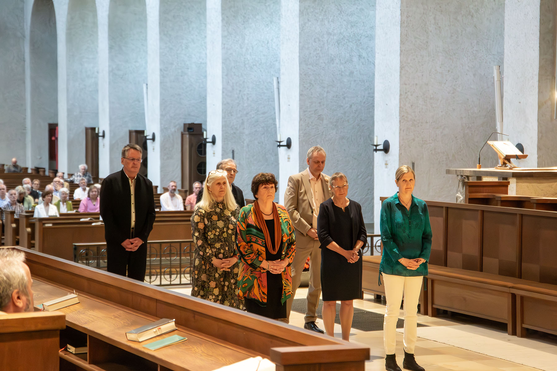 Drei Männer und vier Frauen im Altarraum
