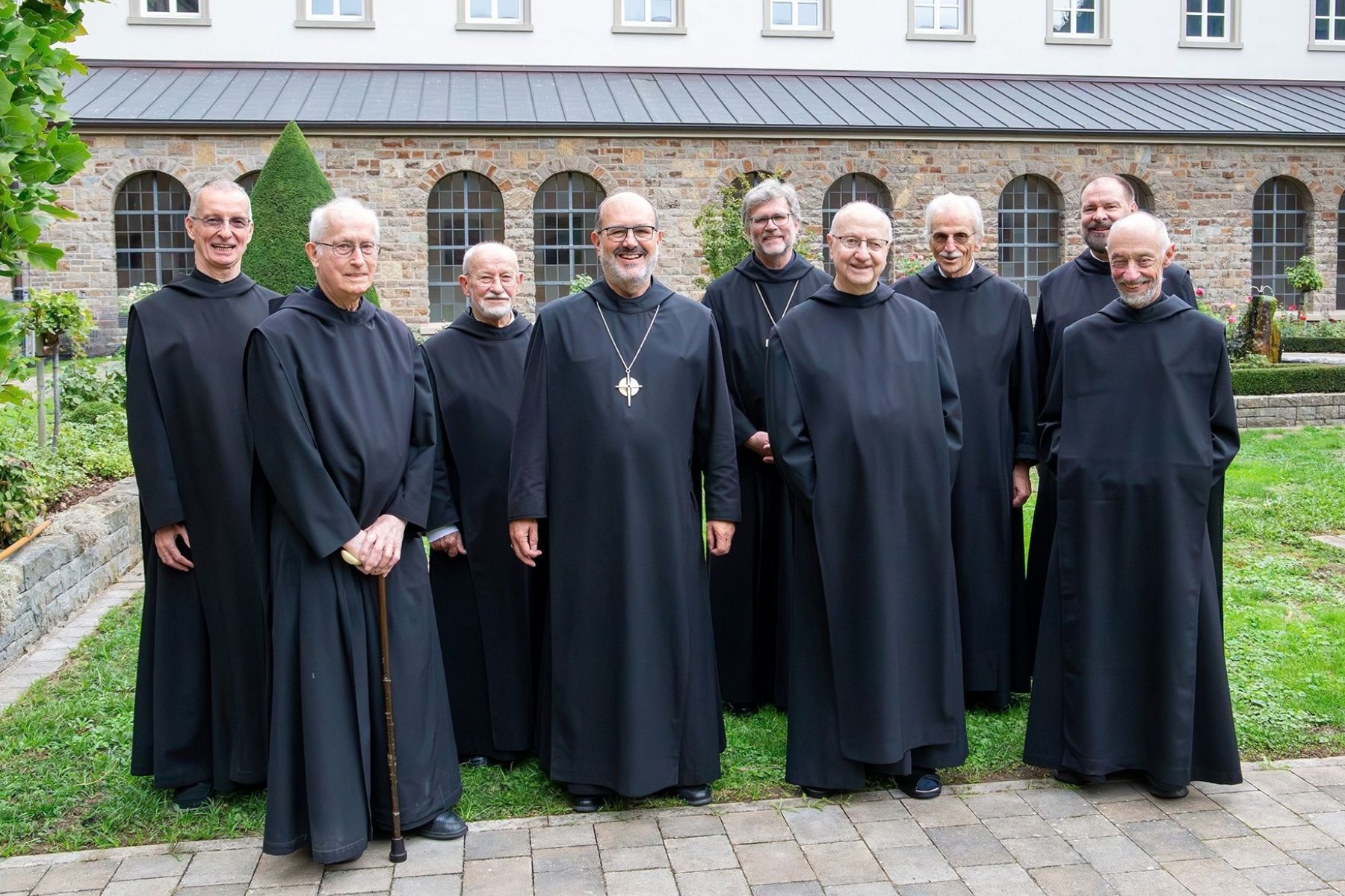 Gruppe mit neun Mönchen im Garten