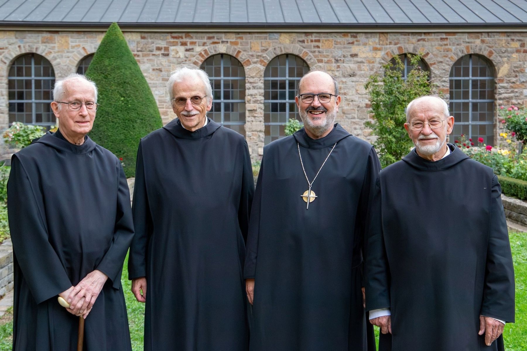 Prieser im Mönchshabit beim Gruppenbild im Garten