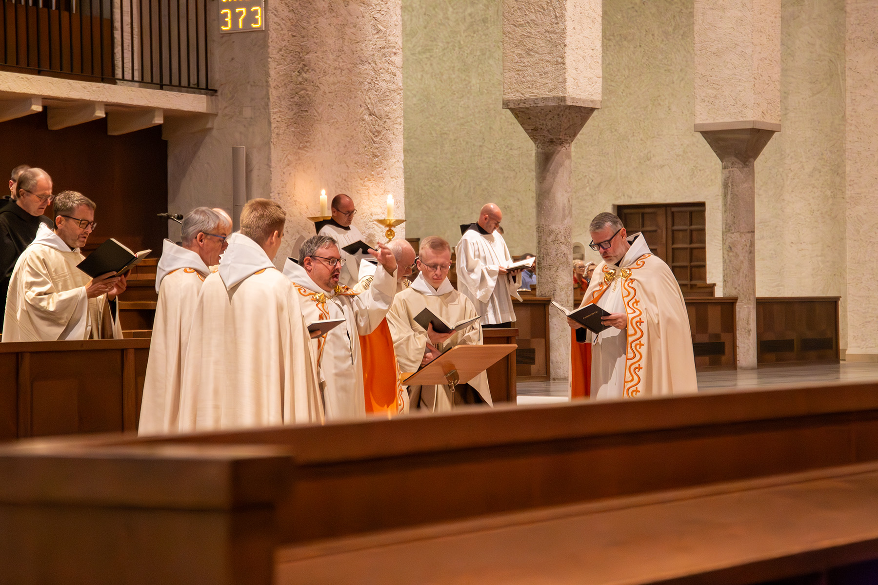 Gruppe von Mönchen im hellen Gewandt singen