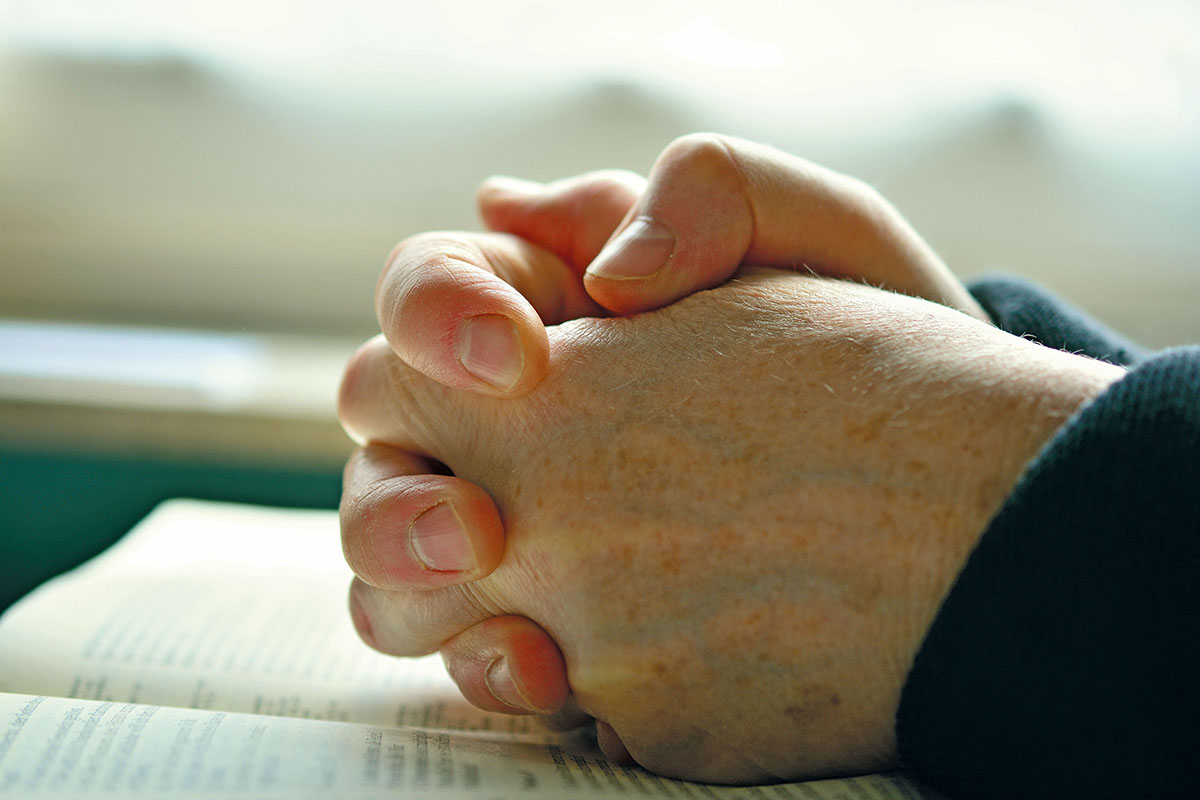 Betende Hände auf einer Bibel