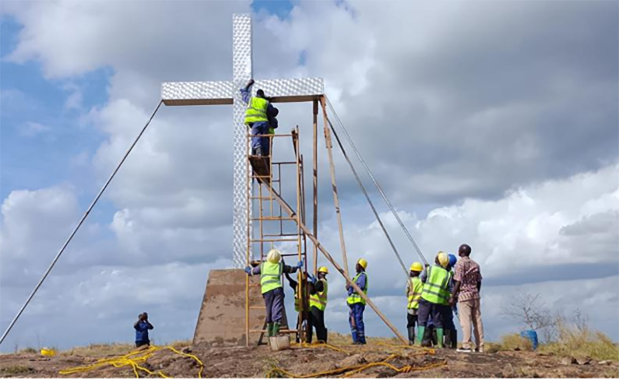 Gruppe von Bauarbeitern, die ein Kreuz erichten
