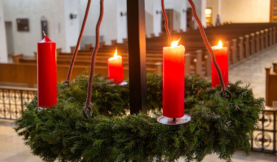 Adventskranz, bei dem drei Kerzen angezündet sind.
